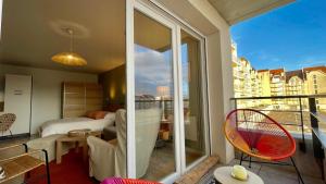 a room with a balcony with a bed and a bedroom at Studio Couleurs d'Opale in Stella-Plage