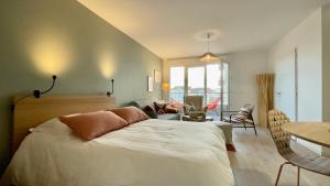 a bedroom with a bed and a living room at Studio Couleurs d'Opale in Stella-Plage