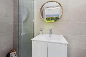 a bathroom with a sink and a mirror at Apollo Panorama Guesthouse in Apollo Bay