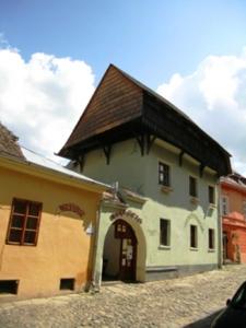 a large white building with a brown roof at Burg Hostel Sighisoara in Sighişoara