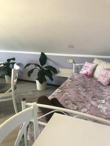ベレホヴェにあるVilla Galiciaのピンクの枕と植物が備わるベッドルーム1室が備わります。