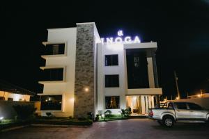 Inoga Luxury Hotel في دودوما: سيارة متوقفة أمام مبنى في الليل