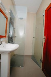 La salle de bains est pourvue d'un lavabo et d'une douche. dans l'établissement Inoga Luxury Hotel, à Dodoma