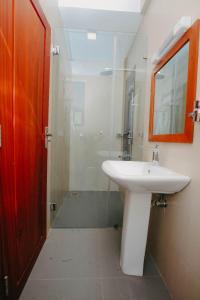 a bathroom with a sink and a glass shower at Inoga Luxury Hotel in Dodoma