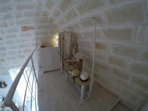 Pokój z kamienną ścianą ze stołem i krzesłem w obiekcie La dolce casa - Puglia last minute w mieście Carovigno