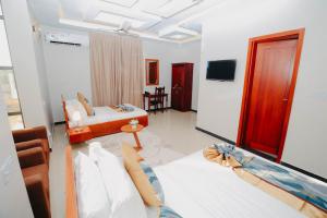 Cette chambre comprend 2 lits et une télévision. dans l'établissement Inoga Luxury Hotel, à Dodoma