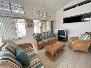 a living room with two couches and a tv at Seagaze beach house is perfect for family, a few steps to the beach in Saint James