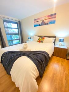 a bedroom with a large bed with a large window at Swanky Central Apartment with Free Wifi (Sleeps 4) in Birmingham