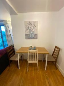 a dining room table with two chairs and a table with a vase at Swanky Central Apartment with Free Wifi (Sleeps 4) in Birmingham