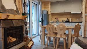 a kitchen with a fireplace and a table and chairs at Mały Zakątek Dzianisz "Balia na wyłączność" in Dzianisz
