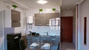 a kitchen with blue cabinets and a table with glasses at Grace resident stúdió apartman in La Mata