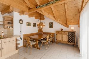 una cucina con tavolo e sedie in legno di Ferienwohnung Seeglück mit großzügigem Südbalkon und herrlichem Seeblick a Schluchsee