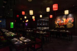 a dining room with tables and chairs and chinese lights at Ashley Tang Menteng Jakarta in Jakarta