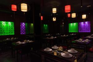 a dining room with tables and colorful stained glass windows at Ashley Tang Menteng Jakarta in Jakarta