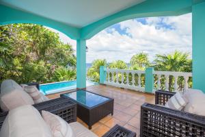 a patio with chairs and a table and a pool at Coral Vista #3 Home in West End