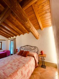 sypialnia z łóżkiem w pokoju z drewnianym sufitem w obiekcie Tenuta Le Sorgive Agriturismo w mieście Solferino