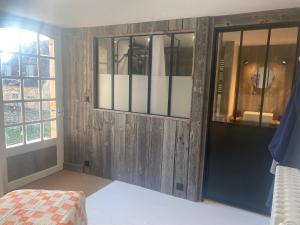Pokój z drewnianymi ścianami, oknem i łóżkiem w obiekcie Maison Maleville w mieście Domme