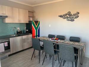 Lion House, 3 bedroom House next to Pilanesberg and Sun City في Mogwase: مطبخ مع طاولة وكراسي في مطبخ