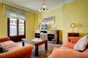 een woonkamer met 2 banken en een salontafel bij Apartamento dúplex centro con garaje gratuito in Ronda