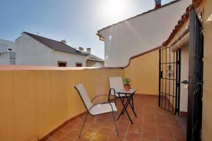 a patio with two chairs and a table on a balcony at Apartamento dúplex centro con garaje gratuito in Ronda
