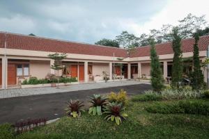 un edificio con muchas plantas en un patio en RedDoorz Plus Syariah at Hotel Indonesia Kajen en Pekalongan