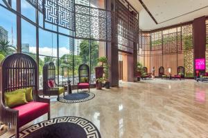 a lobby with red chairs and a large window at Ashley Tang Menteng Jakarta in Jakarta