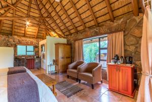 a bedroom with a bed and a chair in a room at Skyhaven Lodge in Ohrigstad +20 photos
