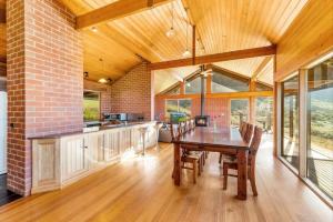 a kitchen and dining room with a wooden table at Apollo Panorama Guesthouse in Apollo Bay