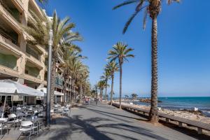 a sidewalk next to the beach with palm trees at Grace resident stúdió apartman in La Mata