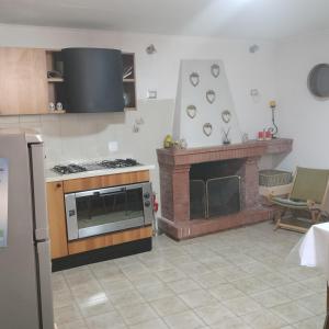 a kitchen with a stove and a fireplace at Il giardino di Emilia in Raviscanina