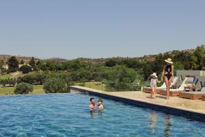a group of people in the swimming pool at a resort at Minthis Resort in Paphos