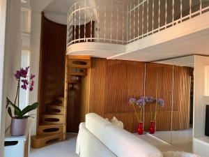 a living room with a white couch and a television at APPARTAMENTO DI CHARME NEL CUORE DI SANREMO in Sanremo