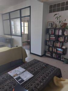 a living room with a table and a book shelf at Joli appartement avec vue. Dakar Plateau. Lumineux et fleurie in Dakar