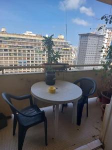 a table and chairs on a balcony with a window at Joli appartement avec vue. Dakar Plateau. Lumineux et fleurie in Dakar