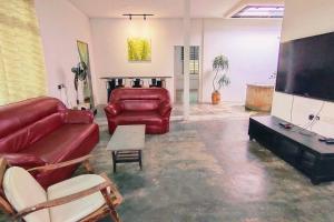 a living room with a red couch and a flat screen tv at 281 Kulai johor gathering 18pax 5BR near Sawit Mural in Kulai