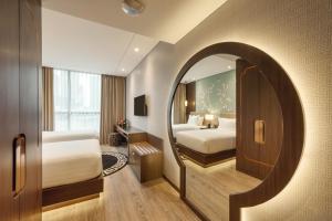 a bedroom with two beds and a mirror at Ashley Tang Menteng Jakarta in Jakarta +37 photos