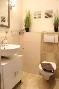 een witte badkamer met een wastafel en een toilet bij Mein Lieblingsplatz (App.21) in Sankt Peter-Ording