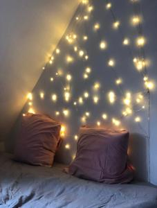 a room with a bed with lights on the wall at Cosy studio Saint-Lazare in Paris
