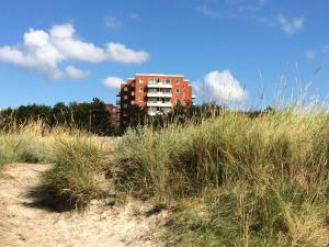 ein hohes Gebäude inmitten eines Strandes mit hohem Gras in der Unterkunft Mein Lieblingsplatz (App.21) in Sankt Peter-Ording