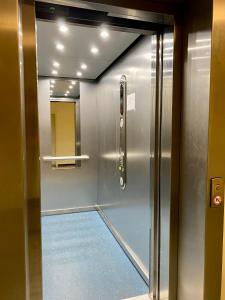 une porte d'ascenseur avec un sol bleu dans une pièce dans l'établissement Mein Lieblingsplatz (App.21), à Sankt Peter-Ording