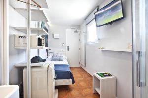 a small room with a bed and a flat screen tv at Ryans Pocket in Ibiza Town