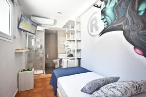 ein Schlafzimmer mit einem Bett und einem TV in einem Zimmer in der Unterkunft Ryans Pocket in Ibiza-Stadt