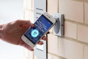 a person holding a cell phone in front of a wall at Brera Serviced Apartments Stuttgart in Stuttgart