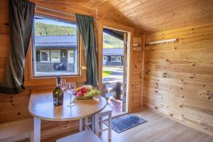 ein Esszimmer mit einem Tisch und einem Fenster in einer Blockhütte in der Unterkunft Topcamp Mosjøen - Helgeland in Mosjøen