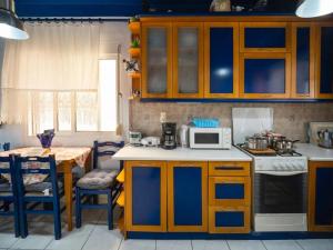 a kitchen with wooden cabinets and a microwave and a table at Savas House in Paralía Avdhíron