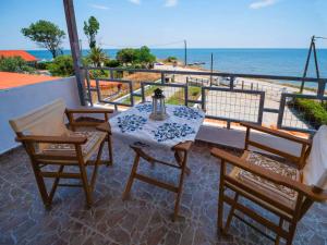 a table and chairs on a balcony with the ocean at Savas House in Paralía Avdhíron