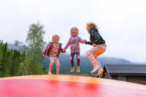 a group of three girls jumping on a trampoline at Topcamp Mosjøen - Helgeland in Mosjøen