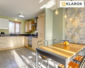 Una cocina con una mesa de comedor y sillas de madera. en LARGE 4 Bedroom Semi-Detached House Sleeps 7 By Klarok Short Lets & Serviced Accommodation, en Peterborough