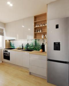 a kitchen with white cabinets and a refrigerator at Luksusowy loft, z bezpłatnym parkingiem w centrum. in Wyszków