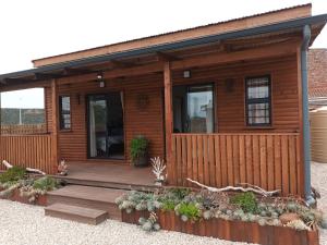 a log cabin with a porch and a deck at Chameleon Lodge in Cannonvale